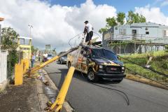 People attempt to remove broken power poles that landed on top a food truck in Puerto Rico after Hurricane Maria.