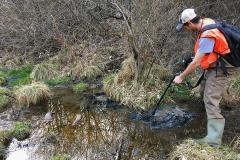 Joshua Woda, a graduate student in geosciences at Penn State, measures methane concentrations in the air. Gas bubbles out of the