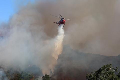 A helicopter drops water on a wildfire in Los Angeles in January 2025